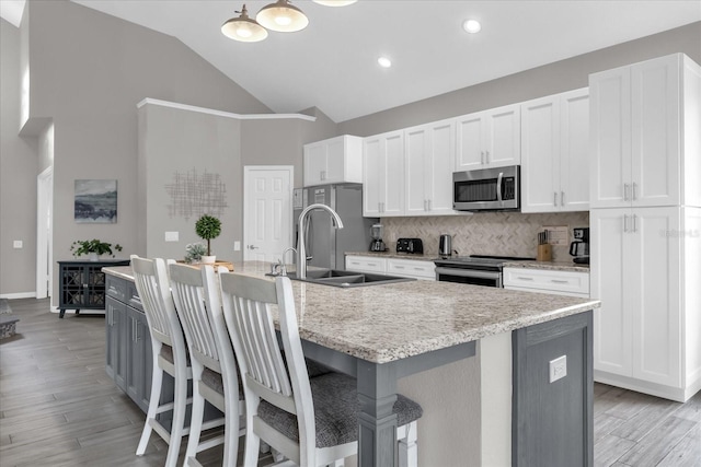 kitchen featuring a kitchen island with sink, sink, and stainless steel appliances