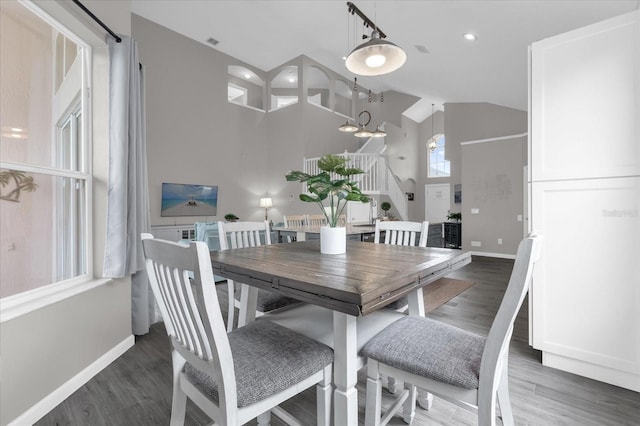 dining space with vaulted ceiling and dark wood-type flooring