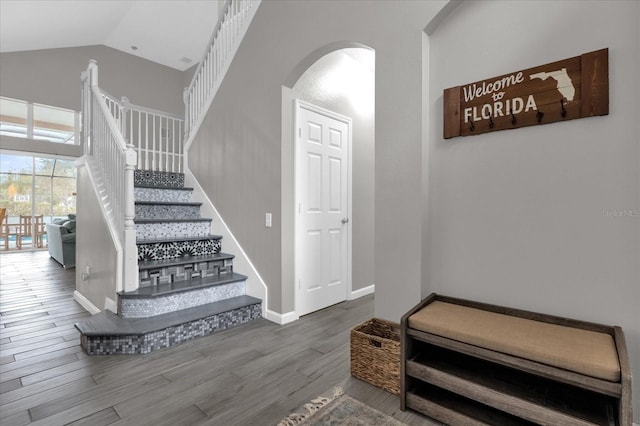 staircase with wood-type flooring and lofted ceiling