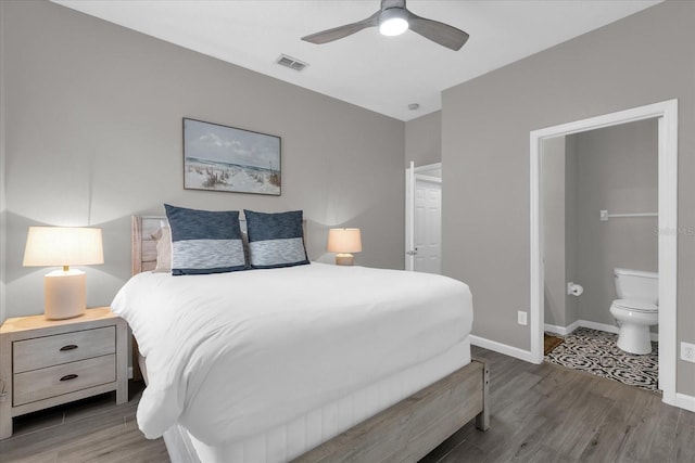 bedroom featuring dark wood-type flooring, ceiling fan, and ensuite bath