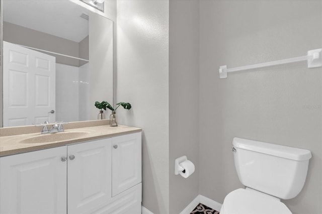 bathroom with toilet, vanity, and a shower