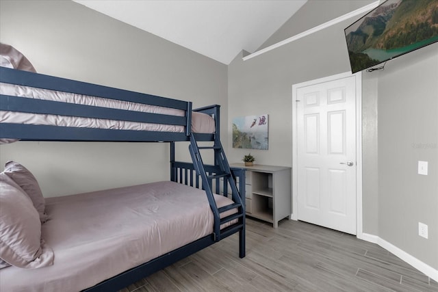 bedroom featuring lofted ceiling and hardwood / wood-style flooring