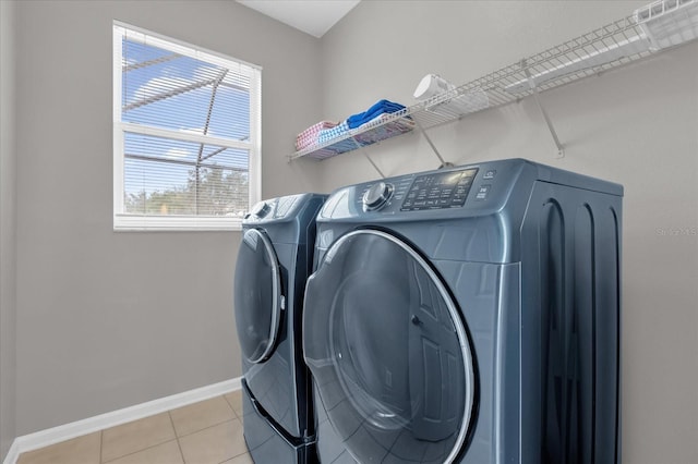 clothes washing area featuring washing machine and dryer and light tile patterned flooring