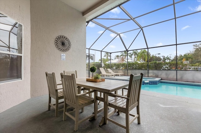 view of patio featuring glass enclosure and a swimming pool with hot tub