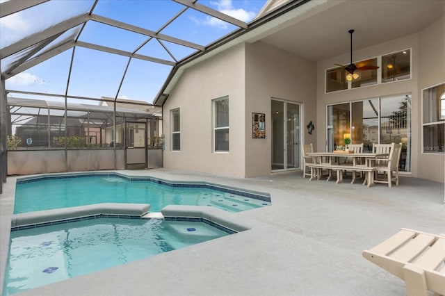 view of pool featuring glass enclosure, a patio area, and ceiling fan