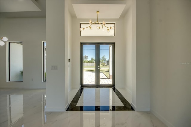 foyer entrance featuring an inviting chandelier and french doors