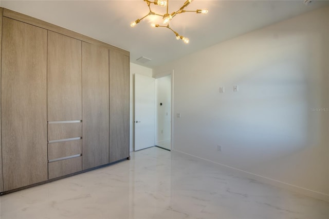 unfurnished bedroom featuring a closet and a notable chandelier