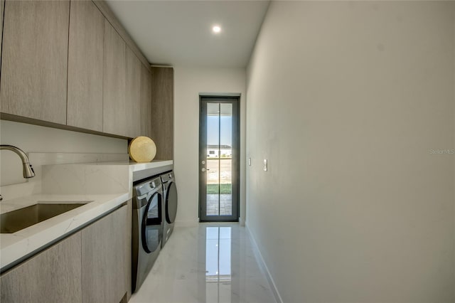 clothes washing area featuring cabinets, separate washer and dryer, and sink