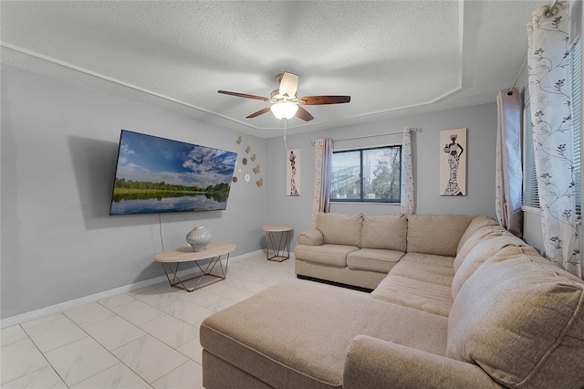 living room with ceiling fan and a textured ceiling