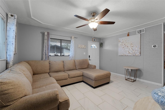 living room featuring ceiling fan and a textured ceiling