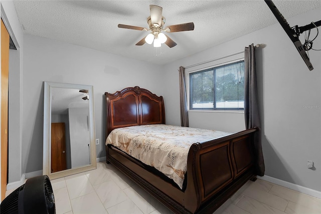 bedroom with ceiling fan and a textured ceiling