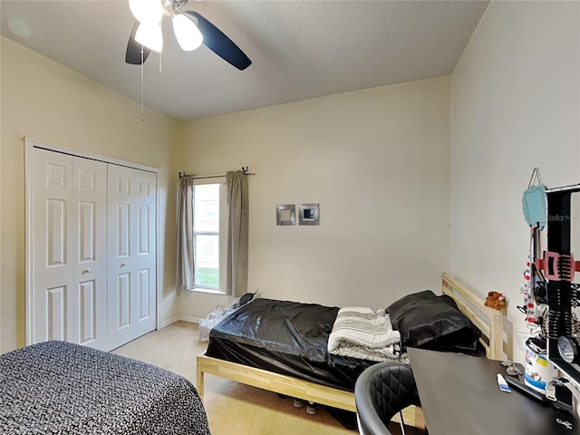 carpeted bedroom featuring ceiling fan and a closet