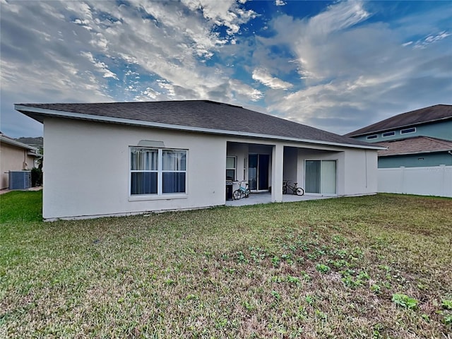 rear view of property featuring central AC, a lawn, and a patio