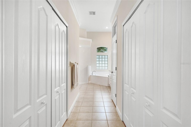 bathroom featuring tile patterned flooring, a bathtub, and crown molding