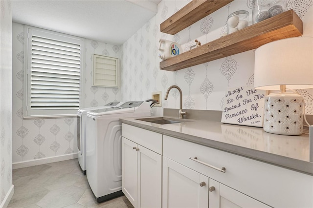 washroom featuring sink, separate washer and dryer, and cabinets