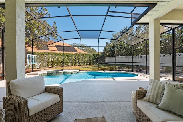 view of pool featuring glass enclosure, an in ground hot tub, an outdoor hangout area, and a patio