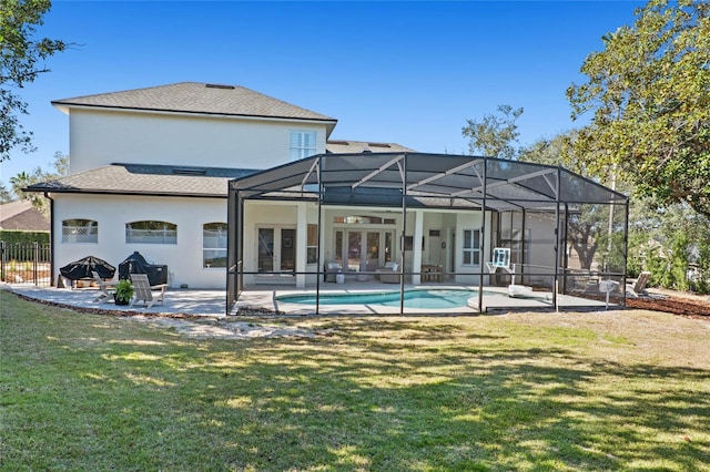 back of property with ceiling fan, a lawn, a lanai, french doors, and a patio