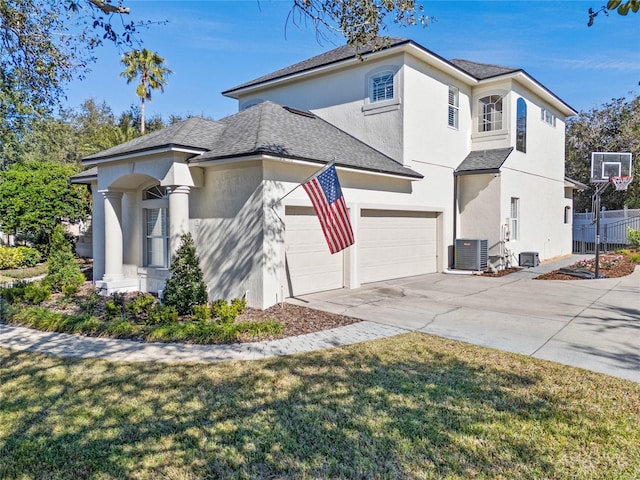 view of front of property with a garage, a front yard, and central AC