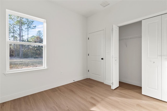 unfurnished bedroom with light hardwood / wood-style floors and a closet