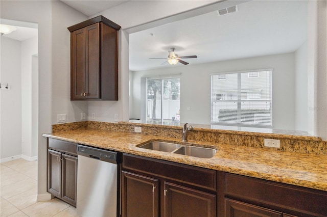 kitchen featuring dark brown cabinetry, sink, light stone counters, light tile patterned floors, and dishwasher