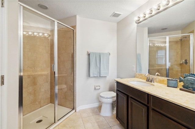 bathroom with tile patterned flooring, vanity, walk in shower, toilet, and a textured ceiling