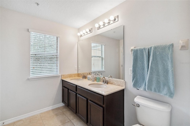 bathroom featuring tile patterned floors, toilet, a textured ceiling, and vanity