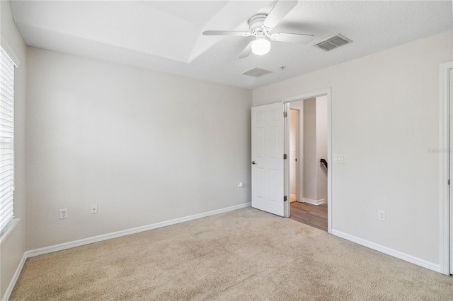 unfurnished bedroom with ceiling fan and light colored carpet