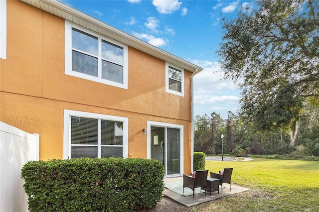 rear view of property featuring a patio area and a lawn