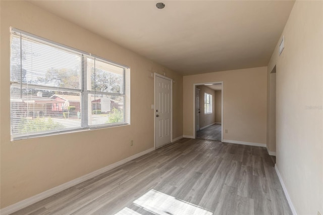 spare room with a wealth of natural light and light wood-type flooring