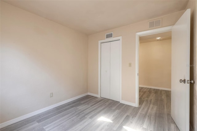 unfurnished bedroom featuring light wood-type flooring and a closet