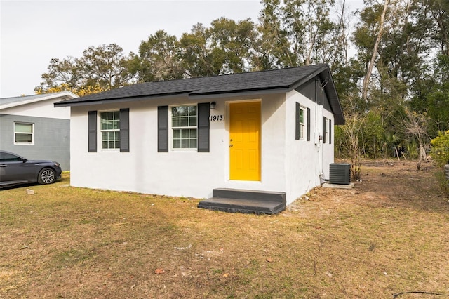 ranch-style home featuring a front yard and cooling unit