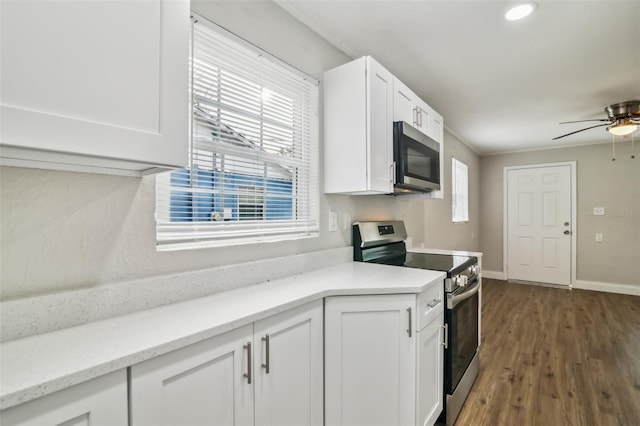 kitchen with plenty of natural light, appliances with stainless steel finishes, dark hardwood / wood-style flooring, and white cabinets