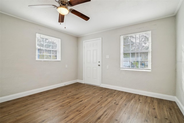 empty room with hardwood / wood-style flooring, ornamental molding, and ceiling fan