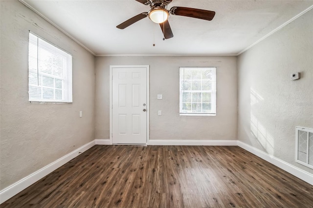 unfurnished room with ceiling fan, dark wood-type flooring, and ornamental molding