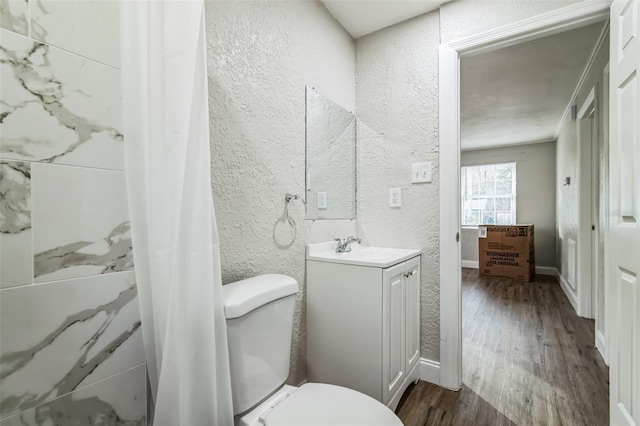 bathroom with toilet, vanity, ornamental molding, and hardwood / wood-style flooring