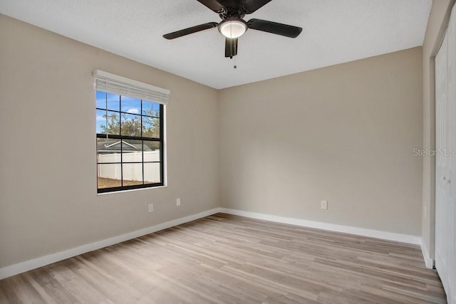 unfurnished room with a textured ceiling, ceiling fan, and light wood-type flooring