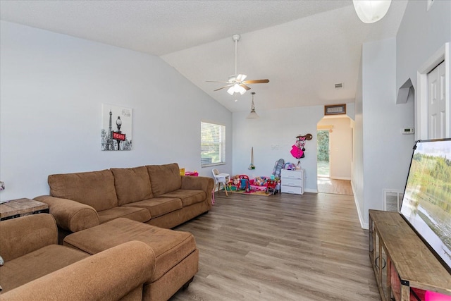 living room featuring ceiling fan, vaulted ceiling, and light wood-type flooring