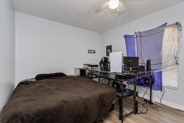 bedroom featuring ceiling fan, a textured ceiling, and hardwood / wood-style flooring