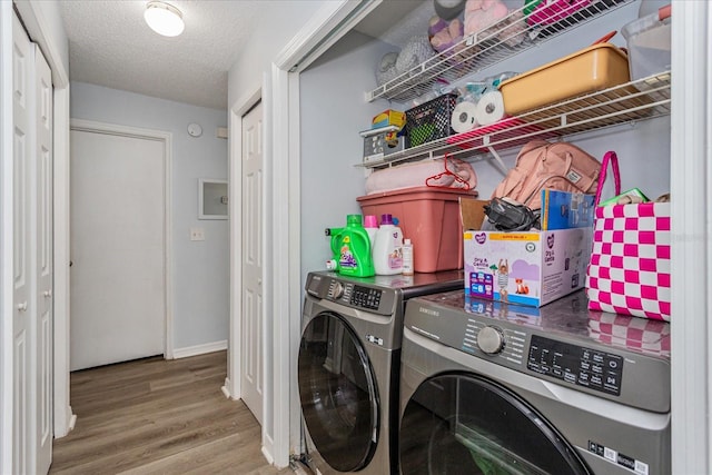 laundry room with a textured ceiling, washer and clothes dryer, and hardwood / wood-style floors