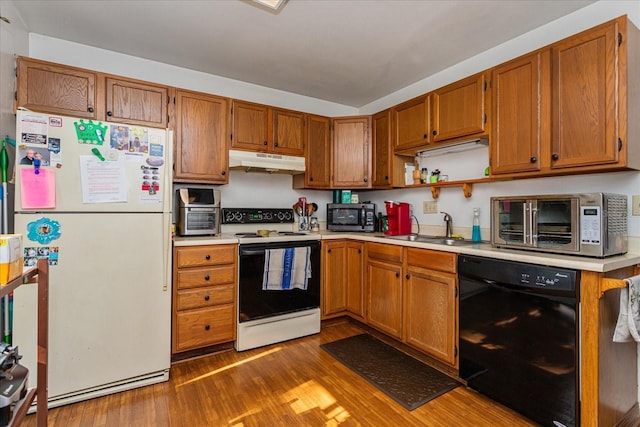 kitchen with wood-type flooring, sink, and white appliances