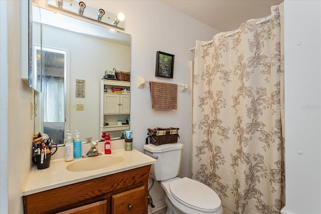 bathroom with toilet, vanity, and curtained shower