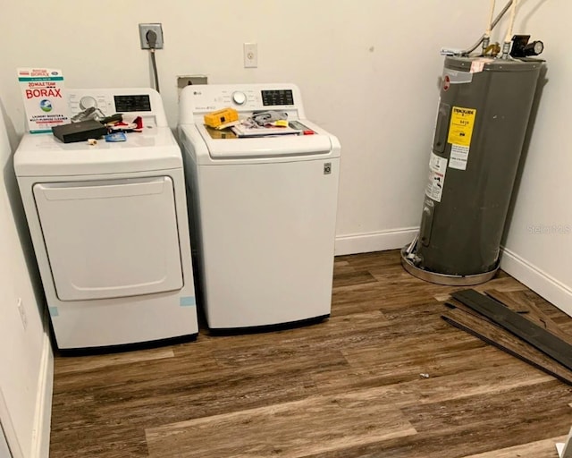 clothes washing area with dark wood-type flooring, separate washer and dryer, and electric water heater