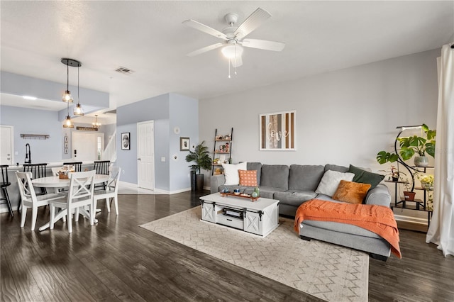 living room featuring ceiling fan and dark wood-type flooring