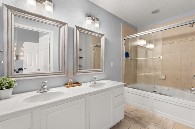 bathroom with bath / shower combo with glass door, tile patterned flooring, vanity, and a textured ceiling