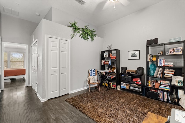 living area featuring dark wood-type flooring and ceiling fan