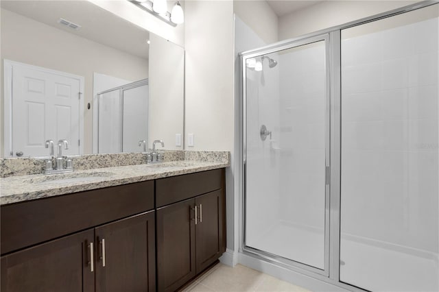 bathroom featuring vanity, tile patterned floors, and walk in shower