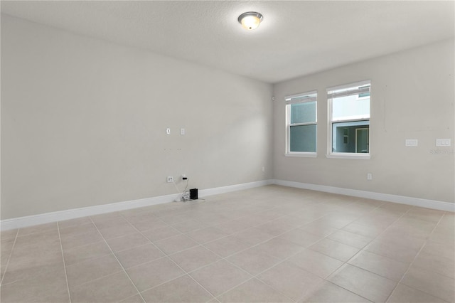 tiled spare room featuring a textured ceiling