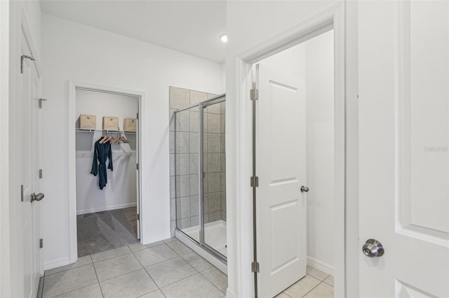 bathroom with tile patterned flooring and a shower with shower door