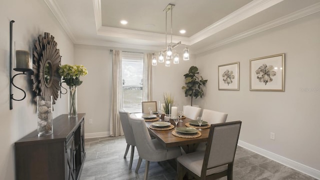 dining room featuring crown molding, a raised ceiling, and a notable chandelier