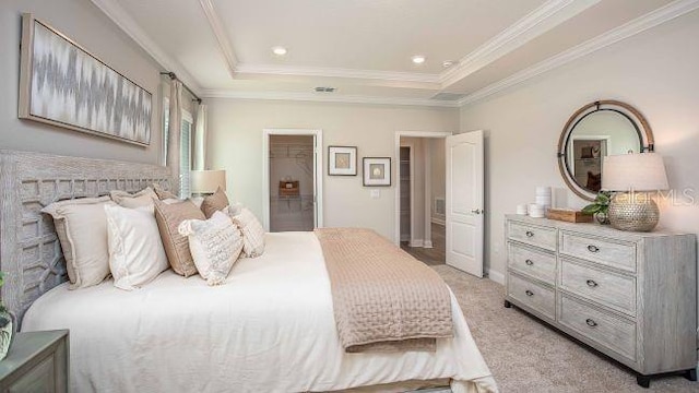 bedroom with a spacious closet, light carpet, ornamental molding, and a raised ceiling